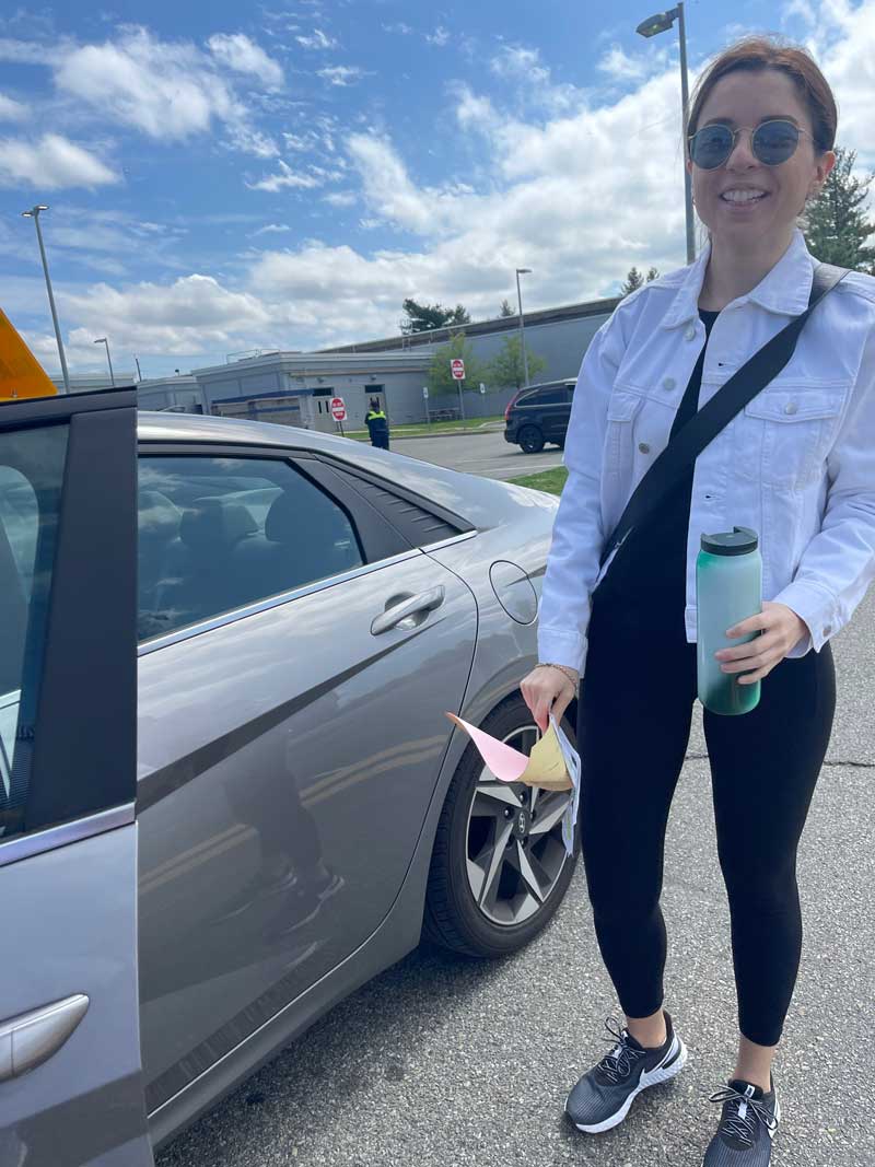 Student standing by the open door of a Golden Wheel car