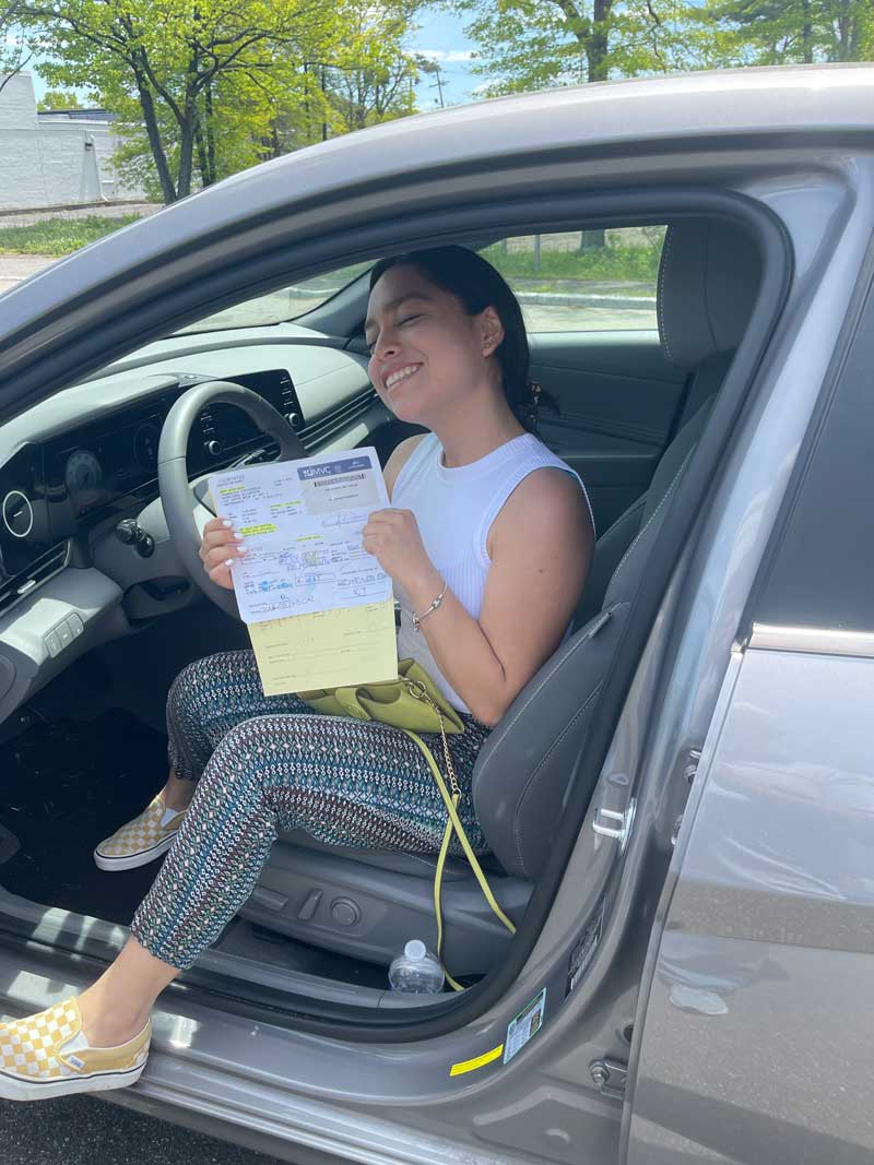 Student in the driver's seat holding MVC paperwork